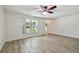 Living room with wood-look tile floors, white walls, natural light and neutral ceiling fan at 1817 West Dr, Clearwater, FL 33755