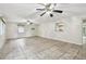 Bright living room featuring neutral tile floors, two ceiling fans, and an air conditioning unit at 1817 West Dr, Clearwater, FL 33755