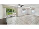 Bright living room featuring neutral tile floors, two ceiling fans, and sliding glass doors to the backyard at 1817 West Dr, Clearwater, FL 33755