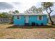 Back of the home featuring a large backyard, new exterior paint, and a small patio area at 1820 Douglas Ave, Clearwater, FL 33755