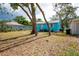 Back of the turquoise home featuring mature trees, a grassy lawn, and a well-maintained exterior at 1820 Douglas Ave, Clearwater, FL 33755