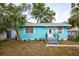 Charming turquoise bungalow featuring a well-manicured lawn, fresh landscaping, and a welcoming front entrance at 1820 Douglas Ave, Clearwater, FL 33755