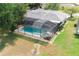 Aerial view of a home featuring a screened-in pool and spa, set in a large backyard at 1949 Tampa Bay Dr, Wesley Chapel, FL 33543