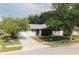 Charming single-story home featuring a well-kept lawn, lovely landscaping, and a welcoming screened-in porch at 1949 Tampa Bay Dr, Wesley Chapel, FL 33543