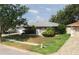 Charming single-story home enhanced with lovely landscaping, lush green lawn, and a delightful screened porch at 1949 Tampa Bay Dr, Wesley Chapel, FL 33543