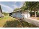 View of home showcasing a garage, a well-maintained lawn and landscaping with a pleasant screened-in porch at 1949 Tampa Bay Dr, Wesley Chapel, FL 33543