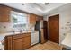 Functional kitchen featuring oak cabinets, a stainless steel refrigerator, and tiled flooring at 1949 Tampa Bay Dr, Wesley Chapel, FL 33543