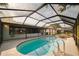This caged pool has a hot tub and a view of a pond at 1949 Tampa Bay Dr, Wesley Chapel, FL 33543