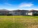 A spacious backyard featuring well-maintained lawn and screened in patio for outdoor living at 19664 Ship Wheel Way, Land O Lakes, FL 34638