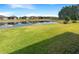 Backyard view of community homes and pond with well-manicured green grass at 19664 Ship Wheel Way, Land O Lakes, FL 34638