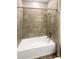Bathroom with shower-tub combination featuring stylish tile surround and modern fixtures at 19664 Ship Wheel Way, Land O Lakes, FL 34638
