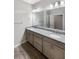 Bathroom featuring double sinks, granite counters, and gray cabinets at 19664 Ship Wheel Way, Land O Lakes, FL 34638