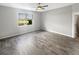 An empty bedroom featuring wood floors, natural light, and a view of the pond from the window at 19664 Ship Wheel Way, Land O Lakes, FL 34638