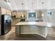 A kitchen with stainless steel appliances, gray cabinets, granite countertops and kitchen island at 19664 Ship Wheel Way, Land O Lakes, FL 34638