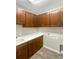 Laundry Room with tile floors, a sink, and plenty of cabinet space at 19664 Ship Wheel Way, Land O Lakes, FL 34638
