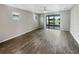 A spacious living area featuring sleek wood floors, natural light, and sliding glass doors to the outdoors at 19664 Ship Wheel Way, Land O Lakes, FL 34638