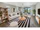 Bright living room with neutral tones, modern furnishings, and a sliding glass door with a view of the water at 19664 Ship Wheel Way, Land O Lakes, FL 34638