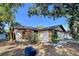 Beautiful single-story home with a well-manicured lawn, lush landscaping, and a stone accent wall at 2031 Dover Ct, Oldsmar, FL 34677