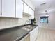 Functional kitchen with tiled floors, dark countertops, and white cabinetry with appliances at 2031 Dover Ct, Oldsmar, FL 34677