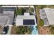 Aerial view of home, showcasing solar panels, fenced backyard, and colorful driveway at 2066 High Ridge Dr, Clearwater, FL 33763