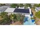 Aerial view of home with solar panels on roof, landscaped yard, and blue driveway at 2066 High Ridge Dr, Clearwater, FL 33763
