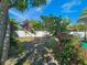 Expansive backyard featuring blooming pink flowers, a white fence, and ample space for relaxation and outdoor enjoyment at 2066 High Ridge Dr, Clearwater, FL 33763