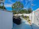 This backyard features a covered grill, purple umbrella and a white fence at 2066 High Ridge Dr, Clearwater, FL 33763