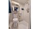 Small white tiled bathroom with toilet, sink, mirror, and shower head at 2066 High Ridge Dr, Clearwater, FL 33763
