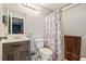 Neutral bathroom offering modern vanity, toilet, and tiled shower with a decorative curtain at 301 Andover S Pl # 175, Sun City Center, FL 33573