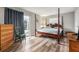 Bright bedroom with wood floors, a four poster bed and sliding glass doors to the screened in porch at 301 Andover S Pl # 175, Sun City Center, FL 33573