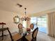 Dining area with glass table, chandelier, and sliding glass doors to patio at 3509 Oak Lake Dr, Palm Harbor, FL 34684