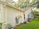 Exterior view of home showcasing utilities and lush greenery at 3509 Oak Lake Dr, Palm Harbor, FL 34684