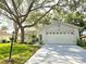 Charming one-story home with a well-manicured lawn, mature tree, and two car garage at 3509 Oak Lake Dr, Palm Harbor, FL 34684