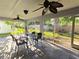 Screened patio showcasing tile flooring, fan, and outdoor dining furniture at 3509 Oak Lake Dr, Palm Harbor, FL 34684