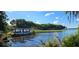Beautiful waterfront view with a covered boat and lush greenery along the shoreline at 3509 Oak Lake Dr, Palm Harbor, FL 34684