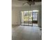 Living room featuring tile floors and a sliding glass door overlooking the waterfront at 376 Moorings Cove Dr # 6C, Tarpon Springs, FL 34689