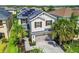Birds eye view of a two-story home equipped with solar panels, well-kept yard, and lush tropical landscaping with palm trees at 4177 Beeswax Ln, Land O Lakes, FL 34638