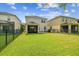 Spacious backyard featuring lush green lawn, screened in porch and black metal fence at 4177 Beeswax Ln, Land O Lakes, FL 34638