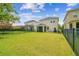 Large backyard with green lawn and screened-in porch in a fenced-in yard at 4177 Beeswax Ln, Land O Lakes, FL 34638