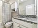 Bathroom with granite countertop, decorative accents, and shower with striped shower curtain at 4177 Beeswax Ln, Land O Lakes, FL 34638