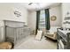 Cozy Bedroom with a gray crib, rocking chair, and green curtains, creating a soothing environment at 4177 Beeswax Ln, Land O Lakes, FL 34638