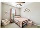 Bedroom with soft pink decor, metal bed frame, and carpeted floors, creating a peaceful ambiance at 4177 Beeswax Ln, Land O Lakes, FL 34638