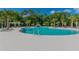 Community pool with zero entry, playground, seating, and lush landscaping at 4177 Beeswax Ln, Land O Lakes, FL 34638