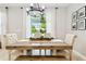 Dining area filled with natural light features a farmhouse table, bench seating, and modern light fixture at 4177 Beeswax Ln, Land O Lakes, FL 34638