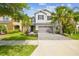 Inviting two-story home featuring a paved driveway, manicured landscaping, and symmetrical palm trees in a desirable location at 4177 Beeswax Ln, Land O Lakes, FL 34638