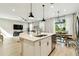 Open-concept kitchen island with stainless steel appliances overlooks the dining and living area filled with natural light at 4177 Beeswax Ln, Land O Lakes, FL 34638