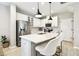 Contemporary kitchen features a center island with seating, stainless steel fridge, and modern pendant lighting at 4177 Beeswax Ln, Land O Lakes, FL 34638