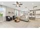 Open-concept living space with wood floors, a comfortable sofa, and seamless flow to the dining area and bright, modern kitchen at 4177 Beeswax Ln, Land O Lakes, FL 34638