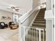 Bright living room leads to carpeted staircase and features a ceiling fan and natural light at 4177 Beeswax Ln, Land O Lakes, FL 34638