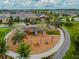 Aerial view of a community playground with swings, slides, and a playset among mature trees at 4177 Beeswax Ln, Land O Lakes, FL 34638